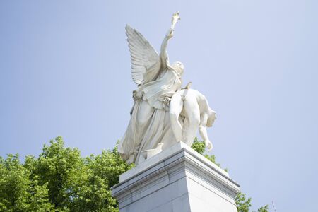 Berlin, Germany - 4th June, 2019: Antique white marble monument of fallen hero against the blue sky. White beautiful statue on the bridge near Museum Island, Berlin, Germany. Bottom up view.のeditorial素材