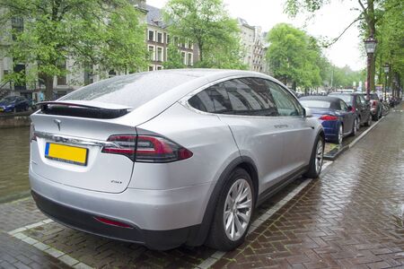 Amsterdam, Netherlands - 5th June, 2019: A close-up of the back of a tesla mobile with logos standing at the rain weather on a street of Amsterdam.のeditorial素材