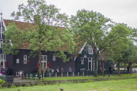 Zaanse Schans, Netherlands - 5th June, 2019: Picturesque calm view of Zaanse Schans, open-air museum in Zaandam. Green and lush vegetation, traditional wooden Dutch houses in cloudy rainy weather.のeditorial素材