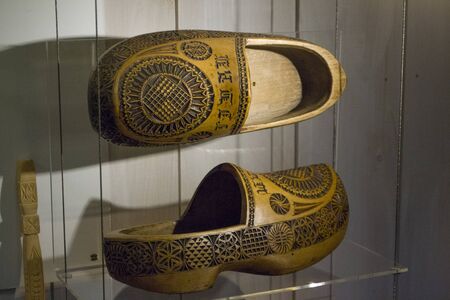 Zaanse Schans, Netherlands - 5th June, 2019: Traditional Dutch hand made wooden farmers shoes. Pair of old klompen in the exhibition hall at the Clog Museum and hand made clogs studio in Zaanse Schansのeditorial素材