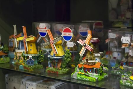 Zaanse Schans, Netherlands - 5th June, 2019: Group of handmade ceramic traditional mills, individually packed, stand on a shelf in a store. Typical souvenirs from Holland. Selective focus.のeditorial素材