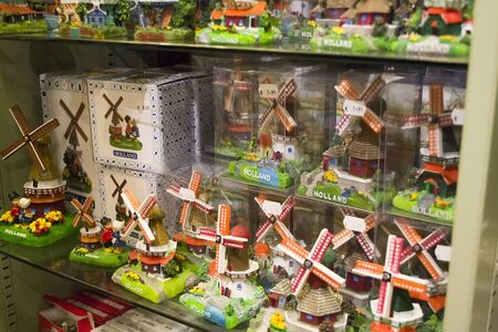 Zaanse Schans, Netherlands - 5th June, 2019: Group of handmade ceramic traditional mills, individually packed, stand on a shelf in a store. Typical souvenirs from Holland. Selective focus.のeditorial素材