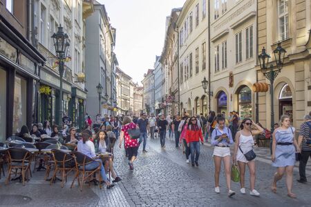Prague, Czech Republic - 8th June, 2019: One of the main streets of Prague. The historical part of the city. Summer cafe on the terrace, souvenir shops and crowd of tourists walking the street.のeditorial素材