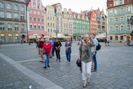 Wroclaw, Poland - June 3th, 2019: Tourists at the medieval market square in Wroclaw in the evening....