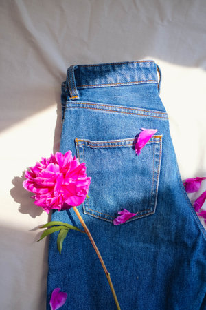 Beautiful pink peony flower on jeans. fashionable concept.の写真素材