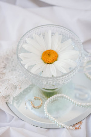 Chamomile flowers in a glass vase with pearlsの写真素材