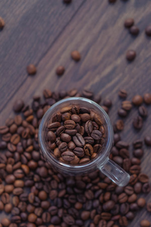 Coffee beans in a glass cup on a wooden background.の写真素材