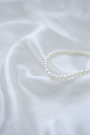 Pearl necklace on white fabric. Shallow depth of field.の写真素材