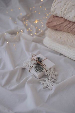 Cozy winter composition. Knitted sweaters, white snowflakes on white background. winter concept.の写真素材