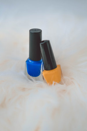 Nail polish bottles on white fur background. selective focus.の写真素材