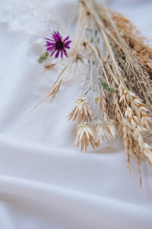 Bouquet of dried flowers on a white fabric.の写真素材