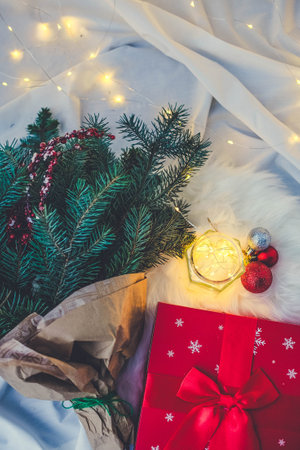 Christmas background with fir branches, gift boxes and decorations on white furの写真素材