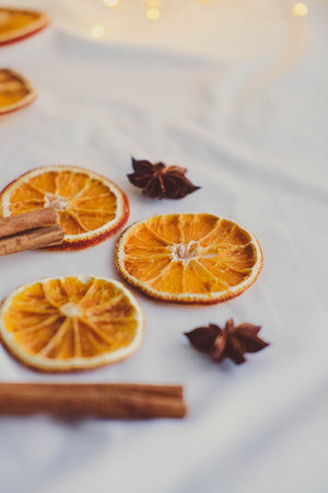 Dried orange slices with cinnamon sticks and star anise on a white background