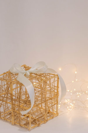 gift box with white ribbon on white background with light garlandの写真素材