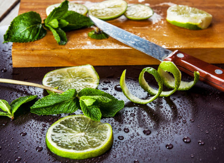 Green limes with mint and water drops on black backgroundの写真素材