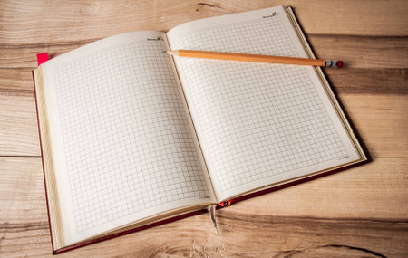 notepad with a pencil on a wooden backgroundの写真素材