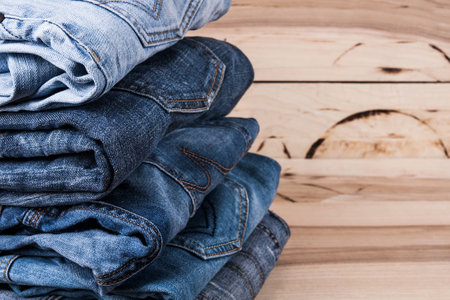 fashionable clothes. pile of jeans on a wooden backgroundの写真素材
