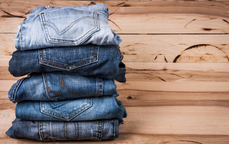 fashionable clothes. pile of jeans on a wooden backgroundの写真素材