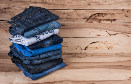 fashionable clothes. pile of jeans on a wooden backgroundの写真素材