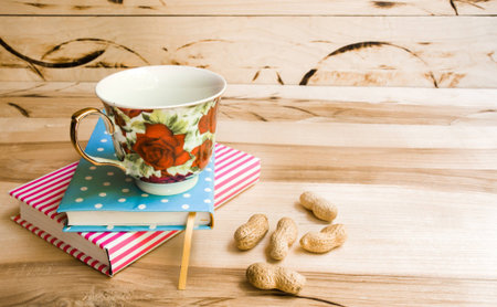 Cup of coffee on saucer with notebook on wooden table backgroundの写真素材