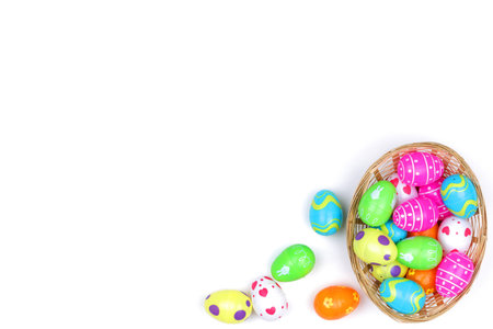 A basket of childs plastic easter eggs on white with copy space