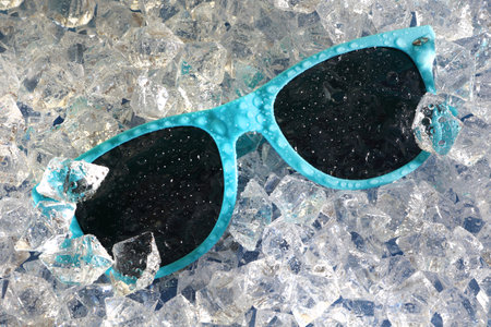 Wet blue sunglasses on a bed of ice