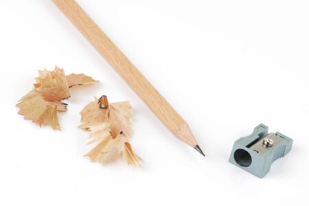 Top view of pencil and sharpener with shavings on whiteの写真素材