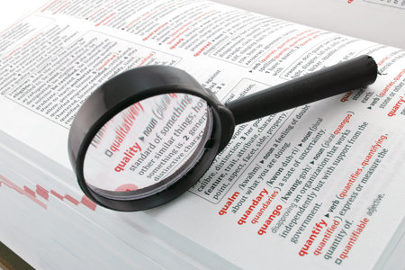 A magnifying glass focussed on the word quality. Quality assurance control enhancement business...
