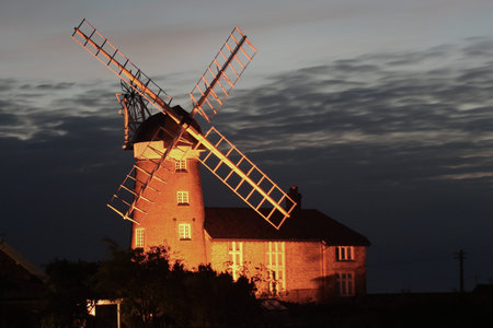 A red brick windmill illuminated at nightの写真素材