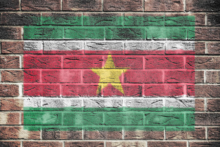 Suriname flag on a brick wall backgroundの写真素材