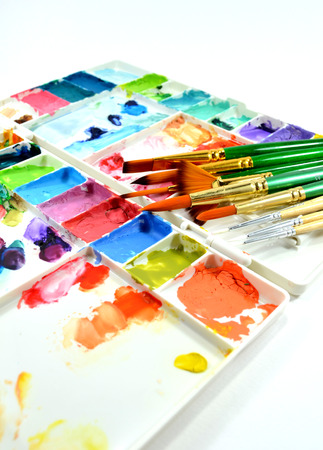 Colorful watercolor palette and diffent type of paintbrushes on white backgroundの写真素材