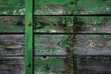old board with peeling off paint, metal lath and botsの写真素材