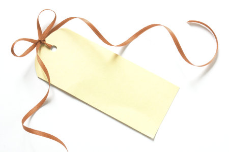blank gift tag with a ribbon isolated on white backgroundの写真素材