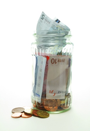 tip jar with bills and coins on white backgroundの写真素材