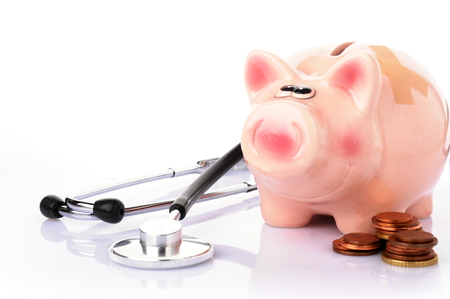 piggy bank with stethoscope and money on white backgroundの写真素材