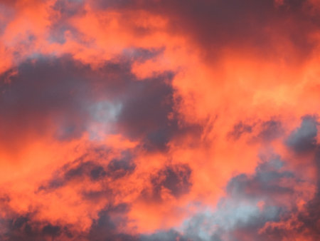 Sunset sky filled with bright orange cloudsの写真素材