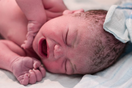 Newborn baby boy crying in delivery room 