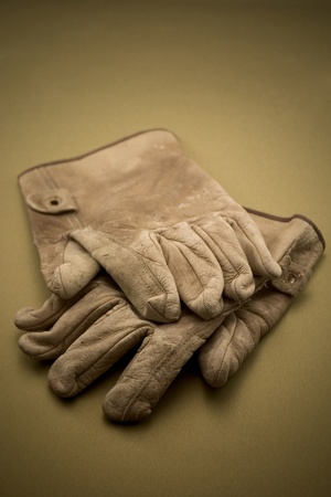 Old tattered leather work glovesの写真素材