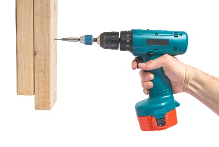 Handyman using cordless drill to drive a wood screw into 2x4sの写真素材