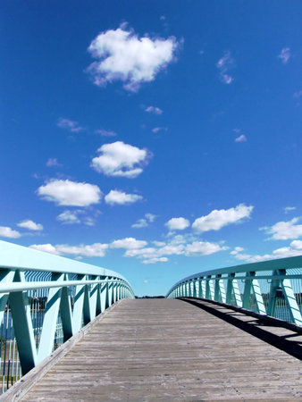 Foot bridge to blue sky, with some white cloudsの写真素材