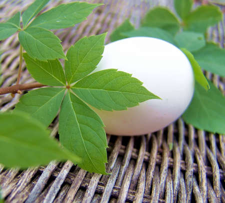 Unpainted white egg on wicker backgroundの写真素材