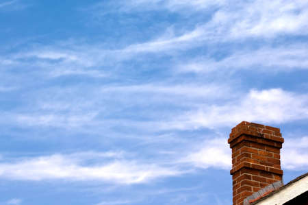 Red brick chimney on blue sky backgroungの写真素材