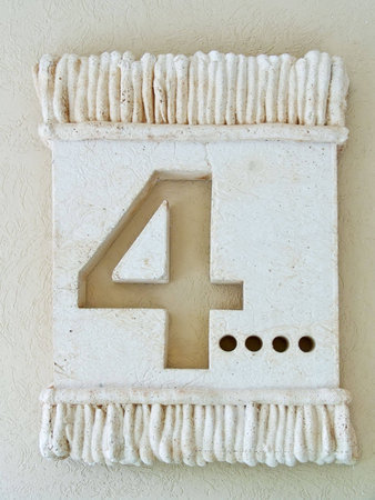 Number 4 barelief in stone. Old-fashion decoration on a wall.の写真素材