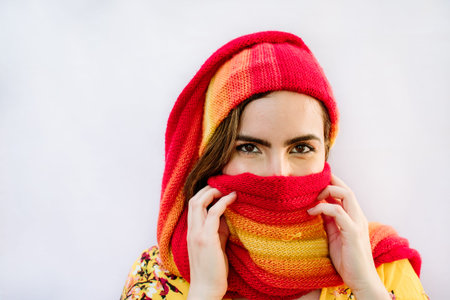 girl with covered face on red background