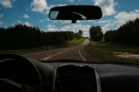 road view from the car with blue sky and clouds and grass aroundの写真素材