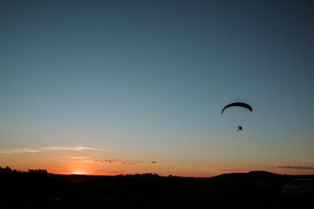 paragliding at sunset in the sky with the sun