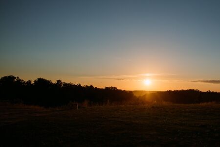 beautiful sunset from a mountain with grass and sky blueの写真素材
