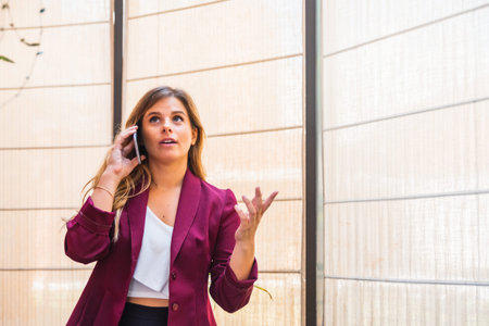 young caucasian woman speaking by mobile phone, with formal clothes in office