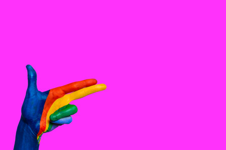 Hand painted in the shape of a gun pointing up, on colorful violet plain background. Copy space.