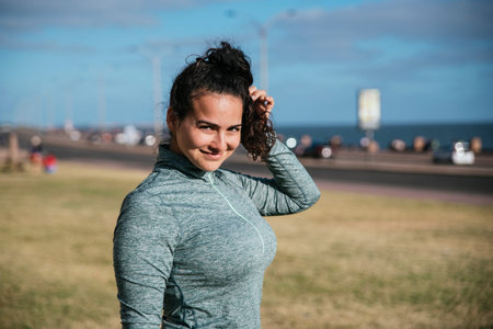 Stock photo of a caucasian woman wearing sportswear smiling and looking to the camera.